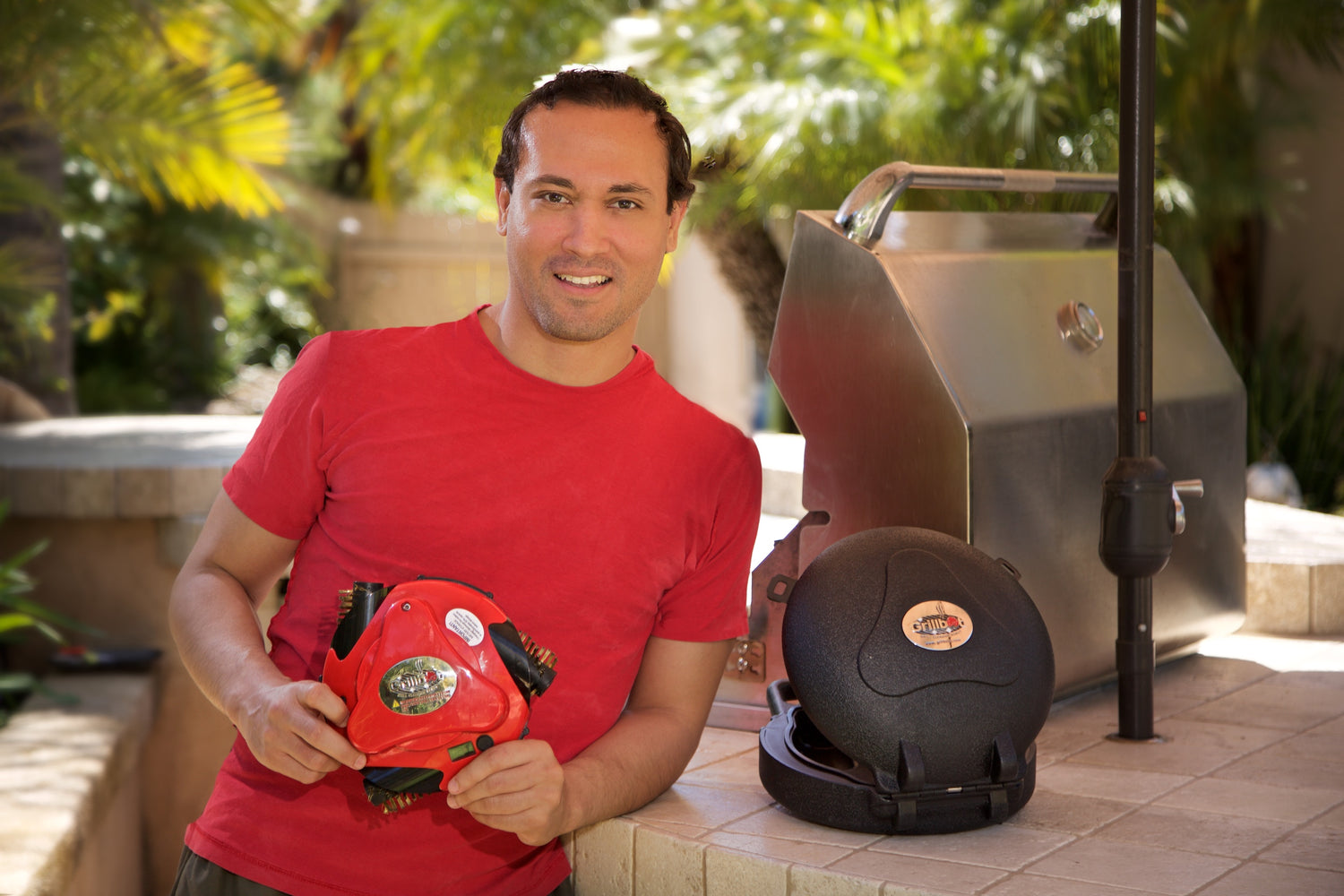 Man Holding Red Grillbot with Black Grillbot Case On Side
