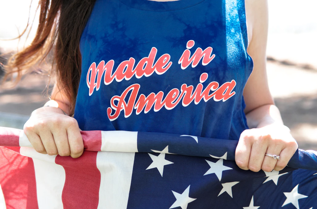 Girl Wearing Made In America Shirt While Holding American Flag 